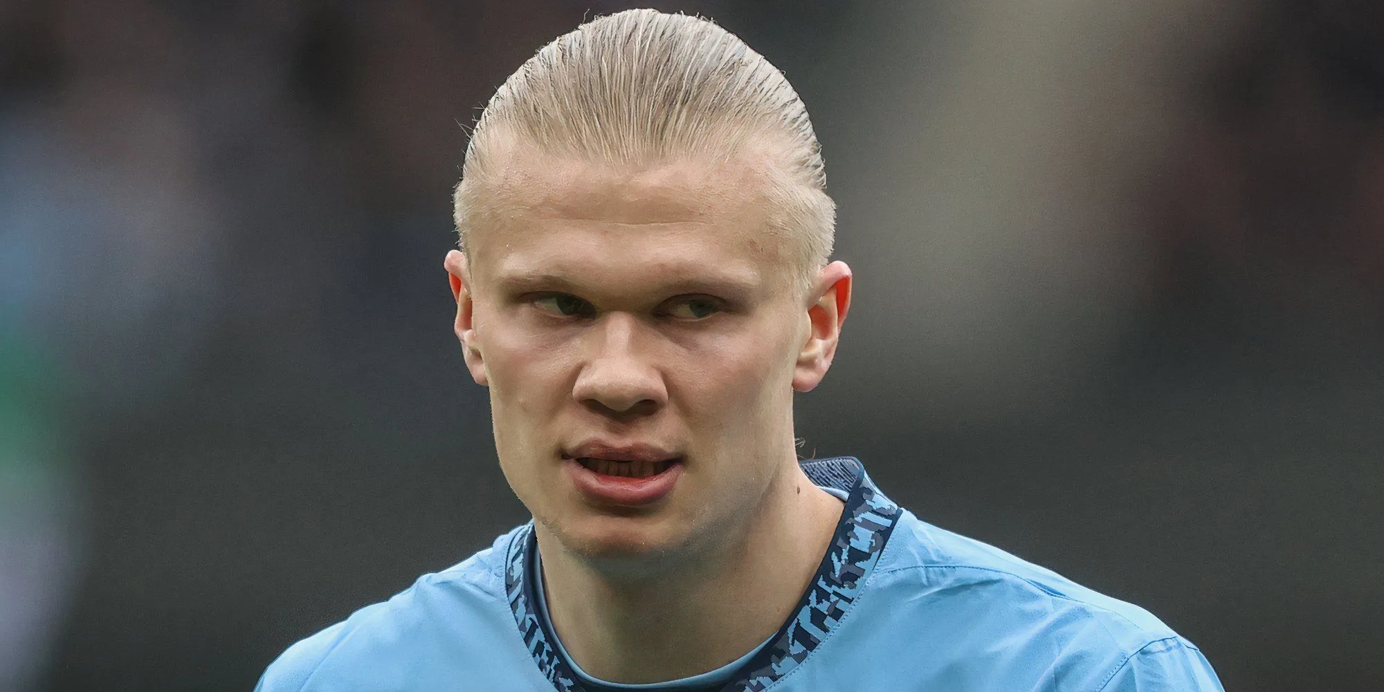 Erling Haaland ngồi trên sân, tỏ vẻ thất vọng trong màu áo Man City